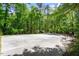 An expansive outdoor court provides recreational opportunities in a lush backyard at 803 Old Mill Rd, Chapel Hill, NC 27514