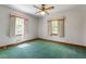 This bedroom includes green carpet, two windows with curtains and ceiling fan at 803 Old Mill Rd, Chapel Hill, NC 27514