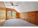 Cozy bedroom featuring knotty pine walls, ceiling fan, and window with view at 803 Old Mill Rd, Chapel Hill, NC 27514