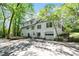 Stunning two-story white home, featuring a garage, a patio, and mature trees surrounding the property at 803 Old Mill Rd, Chapel Hill, NC 27514
