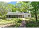 Charming home featuring a screened porch, lush greenery, and a quaint brick pathway at 803 Old Mill Rd, Chapel Hill, NC 27514