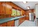 Kitchen with wood cabinets, stainless steel appliances, and a large window overlooking the outdoors at 803 Old Mill Rd, Chapel Hill, NC 27514