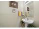 Elegant half-bathroom features a pedestal sink, decorative mirror, and stylish towel arrangement at 8520 Quarton Dr, Raleigh, NC 27616