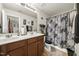 Bathroom featuring double sinks with dark wood cabinets and decorative floral shower curtain at 8520 Quarton Dr, Raleigh, NC 27616