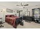 Dark bedroom with plush carpet, decorative ceiling fan, and a sleek black dresser at 8520 Quarton Dr, Raleigh, NC 27616