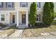 Inviting townhouse facade featuring a brown front door with wreath and charming landscaping with trees on a sunny day at 8520 Quarton Dr, Raleigh, NC 27616