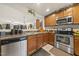 Open kitchen with stainless steel appliances and wood cabinets, overlooking the living room at 8520 Quarton Dr, Raleigh, NC 27616