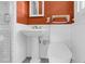 Bathroom featuring a pedestal sink, modern toilet, walk-in shower with bright, rust-colored walls at 905 Cindy St, Cary, NC 27511