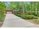 Long driveway leading to a brick home with an attached garage surrounded by lush green landscaping at 905 Cindy St, Cary, NC 27511