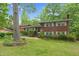 Charming two-story brick home featuring a landscaped front yard with mature trees and manicured shrubbery at 905 Cindy St, Cary, NC 27511
