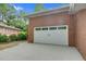 Spacious two-car garage with a brick exterior, a pristine white door, and an extended driveway at 905 Cindy St, Cary, NC 27511