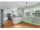 Bright kitchen with white cabinets, granite countertops, wood floors and a chandelier at 905 Cindy St, Cary, NC 27511
