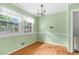 Eat-in kitchen featuring light green walls, wood floors, a chandelier, and large windows at 905 Cindy St, Cary, NC 27511