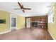 Bright living room with hardwood-look floors, brick fireplace, and updated ceiling fan at 905 Cindy St, Cary, NC 27511