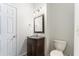 Bathroom features a wooden vanity, a decorative mirror, and a toilet at 909 Grogans Mill Dr, Cary, NC 27519