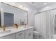 Contemporary bathroom with double vanity sinks, large mirror, and shower at 909 Grogans Mill Dr, Cary, NC 27519