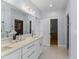 Bright bathroom with dual sinks, quartz countertops, and large mirror leading to a walk-in closet at 909 Grogans Mill Dr, Cary, NC 27519