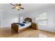 Light-filled bedroom with a fan, wood floors, a bed, and an adjacent nightstand with lamp at 909 Grogans Mill Dr, Cary, NC 27519