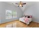 Bedroom featuring hardwood floors, a ceiling fan, and a cozy bed with pink accents at 909 Grogans Mill Dr, Cary, NC 27519