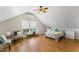 Bright bedroom features hardwood floors, a ceiling fan, window seat, and a comfortable bed at 909 Grogans Mill Dr, Cary, NC 27519