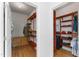 Spacious walk-in closet featuring custom red shelving and wood floors at 909 Grogans Mill Dr, Cary, NC 27519
