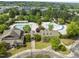 Wide aerial view of community pool and recreation center surrounded by mature trees and a neighborhood at 909 Grogans Mill Dr, Cary, NC 27519