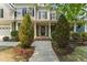 Inviting front porch with a decorative front door, column supports, and landscaped yard at 909 Grogans Mill Dr, Cary, NC 27519