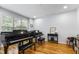 Living room with hardwood floors, natural light, and two pianos at 909 Grogans Mill Dr, Cary, NC 27519