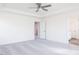 Neutral bedroom features a ceiling fan and opens to an ensuite bathroom and hallway for easy access at 921 Kinglet House Rd, Knightdale, NC 27545