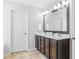 Bathroom featuring a double vanity with dark cabinets and a framed mirror at 112 Gadsbury Dr, Holly Springs, NC 27540