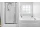 Bright bathroom featuring a walk-in shower and a luxurious soaking tub under a window at 112 Gadsbury Dr, Holly Springs, NC 27540