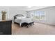 Bright primary bedroom with large windows, a bed and neutral color scheme at 112 Gadsbury Dr, Holly Springs, NC 27540