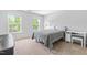 Neutral bedroom featuring plush carpet, two windows, and simple decor at 112 Gadsbury Dr, Holly Springs, NC 27540