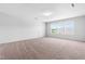 Large bonus room with neutral carpet and a big window providing lots of natural light at 112 Gadsbury Dr, Holly Springs, NC 27540