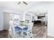 Dining room showing modern table, hardwood floors, and view into kitchen and living room at 112 Gadsbury Dr, Holly Springs, NC 27540