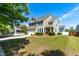 Charming home features manicured lawn, brick accents, a 2-car garage, and a cozy front porch at 112 Gadsbury Dr, Holly Springs, NC 27540