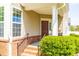 Inviting front porch featuring brick steps, an iron railing and a charming burgundy front door at 112 Gadsbury Dr, Holly Springs, NC 27540