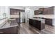 Modern kitchen featuring dark wood cabinets, granite countertops, stainless steel appliances and wood floors at 112 Gadsbury Dr, Holly Springs, NC 27540