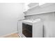 Laundry room featuring white washer and dryer with storage shelves at 112 Gadsbury Dr, Holly Springs, NC 27540