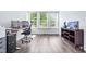 Bright office with hardwood floors, large windows, desk, and custom storage unit at 112 Gadsbury Dr, Holly Springs, NC 27540
