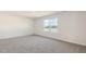 Bedroom with wall-to-wall carpet, neutral paint, and a large window at 112 Global Ave, Fuquay Varina, NC 27526