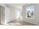 Bright bedroom featuring neutral carpeting, white trim, a double door closet, and a sun-filled window at 112 Global Ave, Fuquay Varina, NC 27526