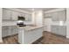 Well-lit kitchen featuring gray cabinets, granite countertops, stainless steel appliances and wood flooring at 112 Global Ave, Fuquay Varina, NC 27526