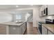 Bright kitchen with granite countertops, gray cabinets, stainless steel appliances and hardwood flooring at 112 Global Ave, Fuquay Varina, NC 27526