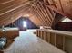 Unfinished attic space with exposed wood beams and a small window at 113 Chesterfield Dr, Cary, NC 27513