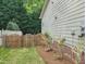 Enclosed backyard features a well-kept lawn, a charming wooden fence, and some shrubbery at 113 Chesterfield Dr, Cary, NC 27513
