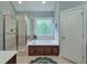 Bright bathroom with a glass-enclosed shower and a soaking tub beneath a decorative window at 113 Chesterfield Dr, Cary, NC 27513