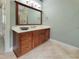 Bathroom vanity with dark wood cabinets, a white countertop, and a large framed mirror at 113 Chesterfield Dr, Cary, NC 27513