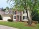 Charming two-story home with a manicured lawn, brick facade, and a three-car garage at 113 Chesterfield Dr, Cary, NC 27513