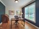 Office with dark blue accent wall and hardwood floors. Includes a desk and a rolling chair at 113 Chesterfield Dr, Cary, NC 27513